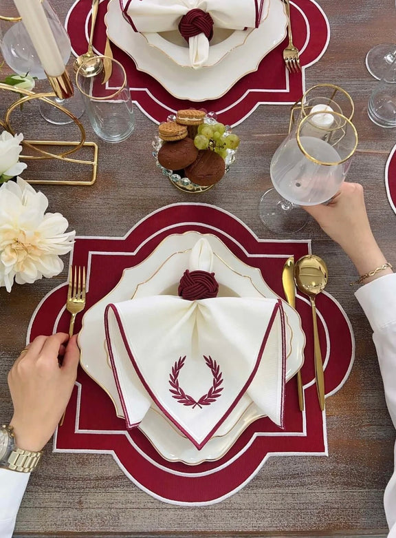 18-piece Milan Design table set in red and white with embroidered details. Includes napkins, placemats, and gold-accented tableware for 6 people.