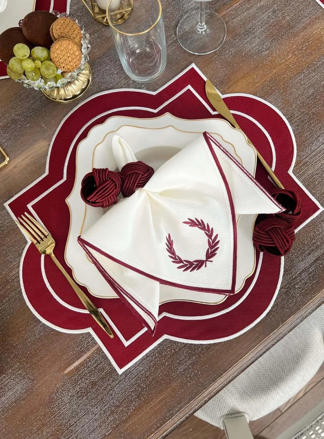 Elegant Milan Design embroidered table set in red and white, featuring waterproof fabric for 6 people. Includes napkins, placemats, and gold-accented tableware.