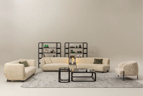 Living room setup featuring Canapé ERGONOMIC sectional sofa, beige armchair, black metal coffee table, and decorative shelving.